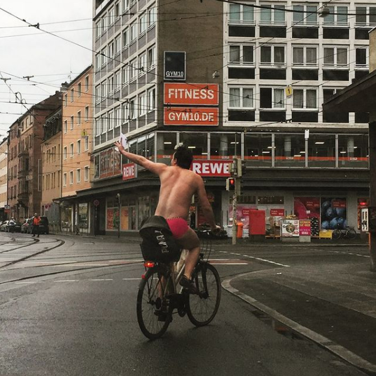 Ein Herr radelt oberkörperfrei und in pinkfarbener Unterwäsche durch die Nürnberger Südstadt