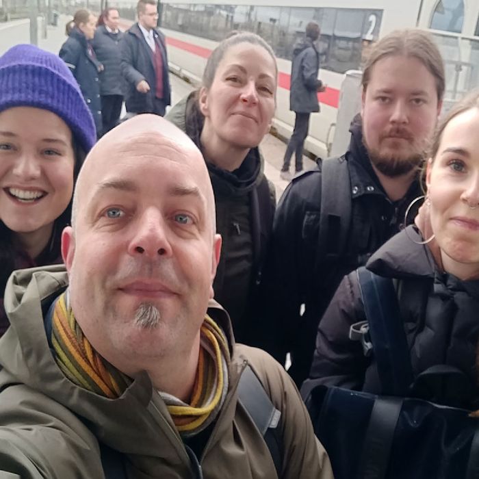 Sophie, Joschi, Angie, Kai und Nina am Bahnhof Nürnberg. Ihr Zug steht bereits im Hintergrund und wartet auf die Passagiere.