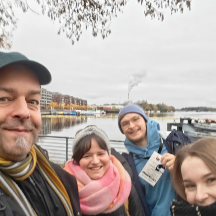 Joschi, Sophie, Jakob und Nina vor einem See auf ihrem Fußweg zur Konferenz