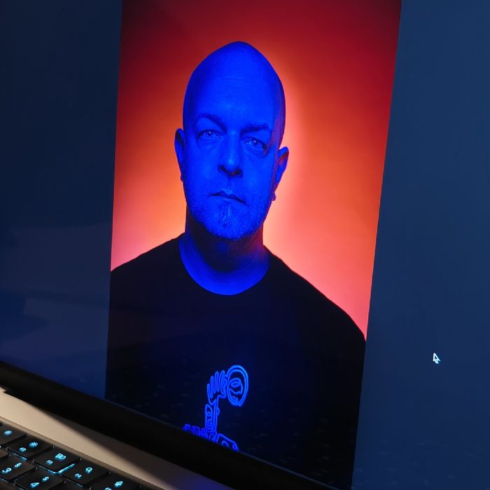 Testportait von Joschi mit blau erleuchtetem Gesicht vor einem mystisch-roten Hintergrund