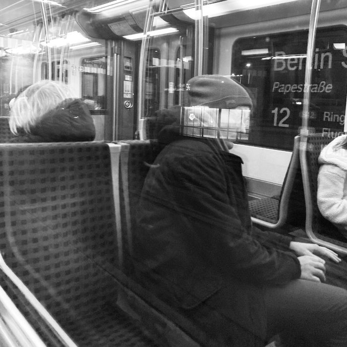 Jakob sitzt in der Berliner Ringbahn. Aus dem Fenster sieht man ein Schild mit der Aufschrift „Berlin“.