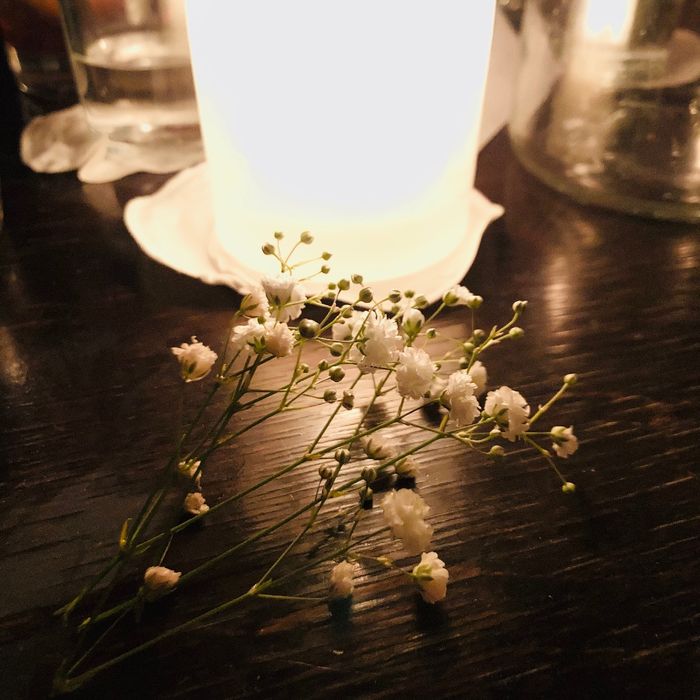 Schleierkraut liegt vor einer Kerze auf dem Tisch.