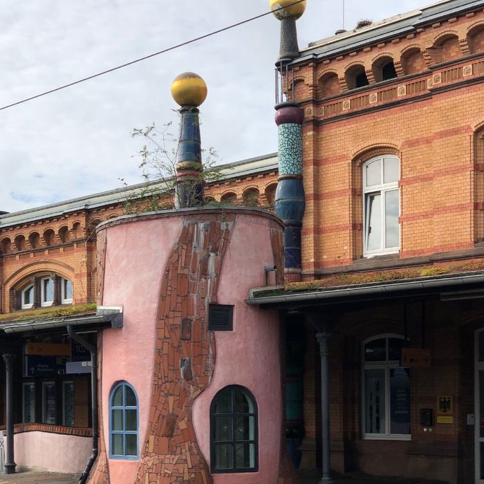 Eine Bahnhoffassade geschmückt mit Mosaik