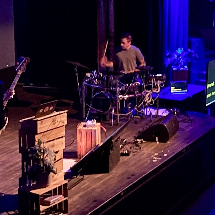 Eine Band auf einer Bühne, in blaues Licht gehüllt