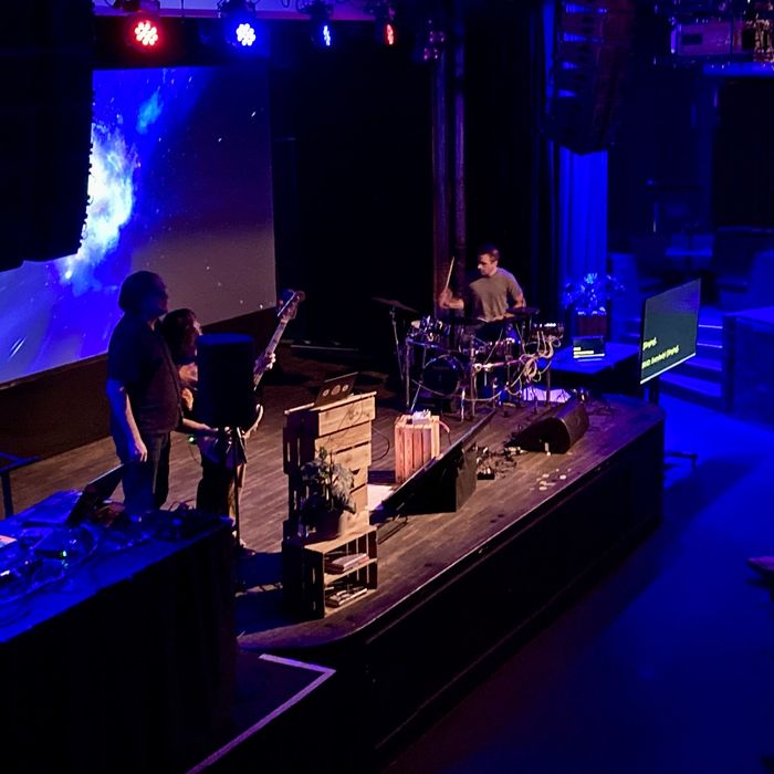 Eine Band auf einer Bühne, in blaues Licht gehüllt