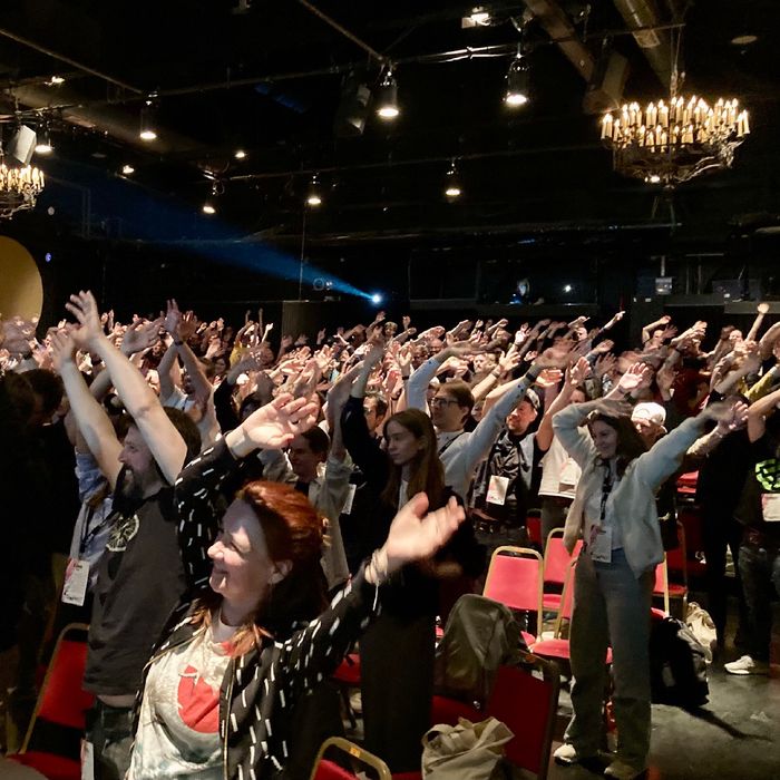 Das Publikum streckt die Arme nach oben.