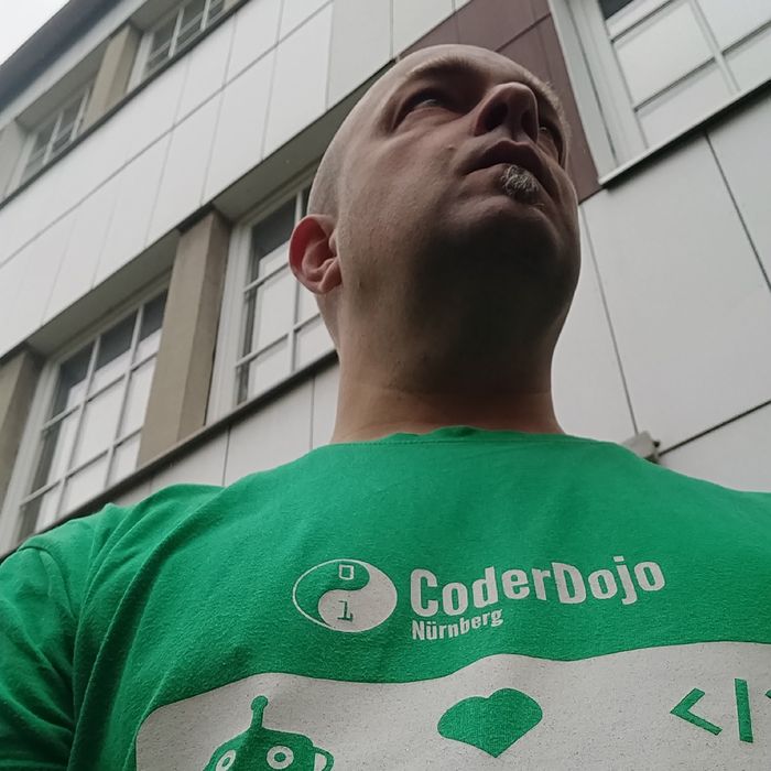Joschi in einem grünen CoderDojo-T-Shirt vor dem Tollwerk-Büro