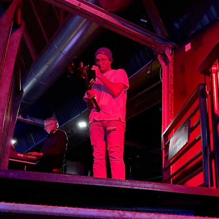 Ein Mann mit einer Kamera in rotes Bühnenlicht gehüllt