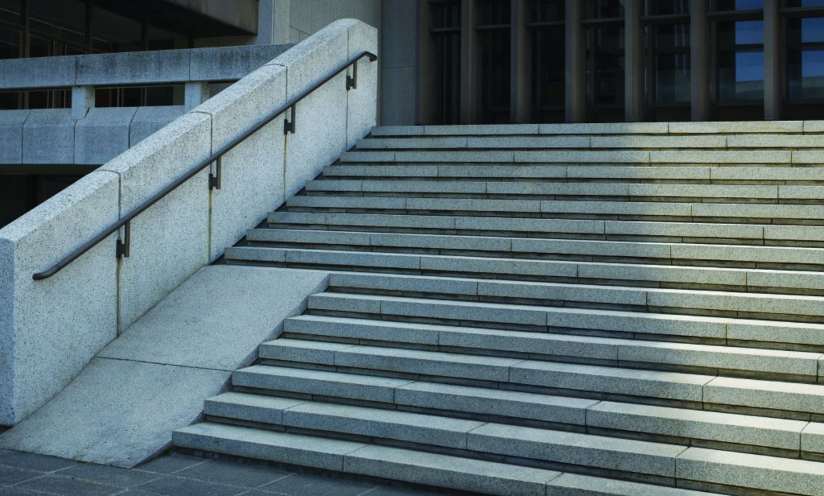 Treppe im öffentlichen Raum. Eine Rampe endet auf halber Höhe inmitten der Stufen.