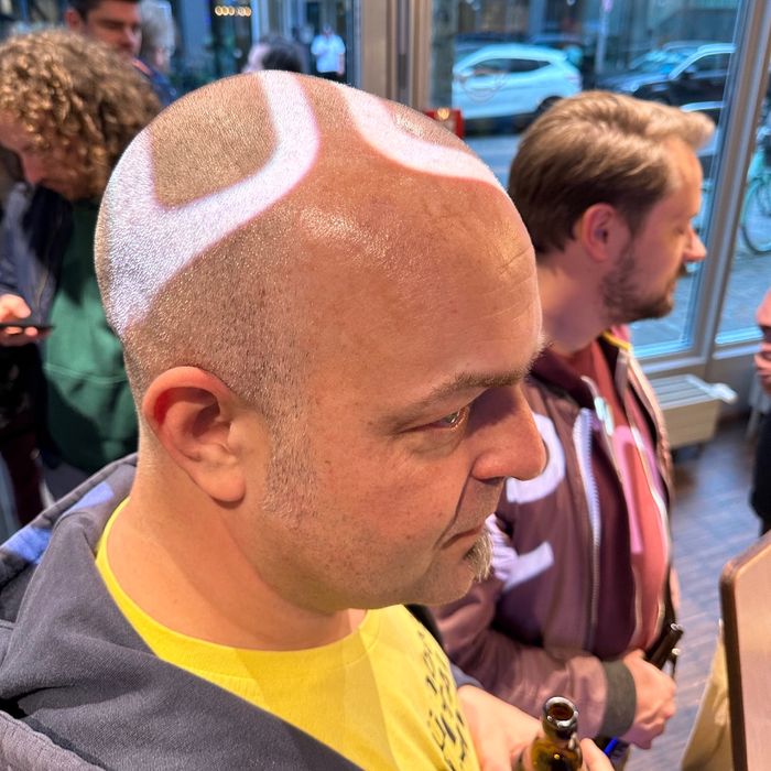 Portrait von Joschi, dessen Glatze von oben mit Kreisen beleuchtet wird.