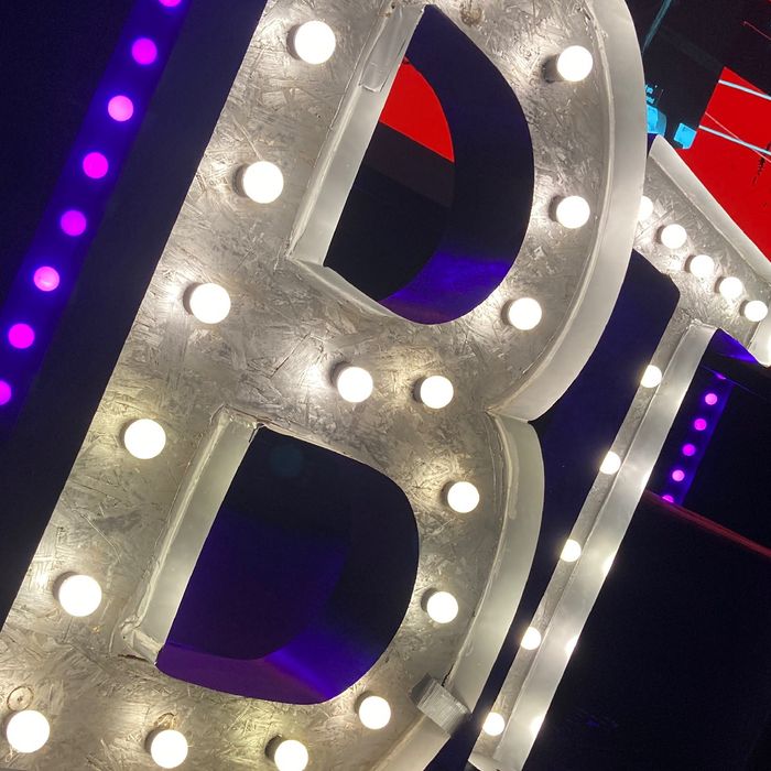 Die Buchstaben B und T auf einer Bphne gefüllt mit leuchtenden Glühlampen