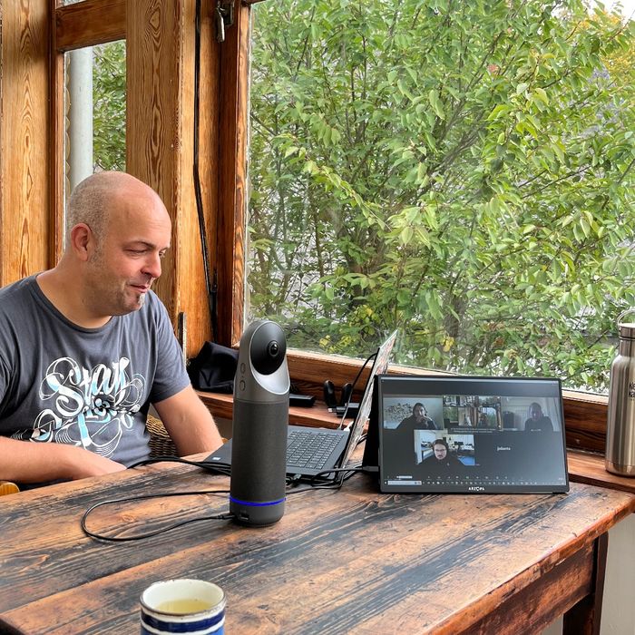 Joschi sitzt im Wintergarten vor dem Laptop