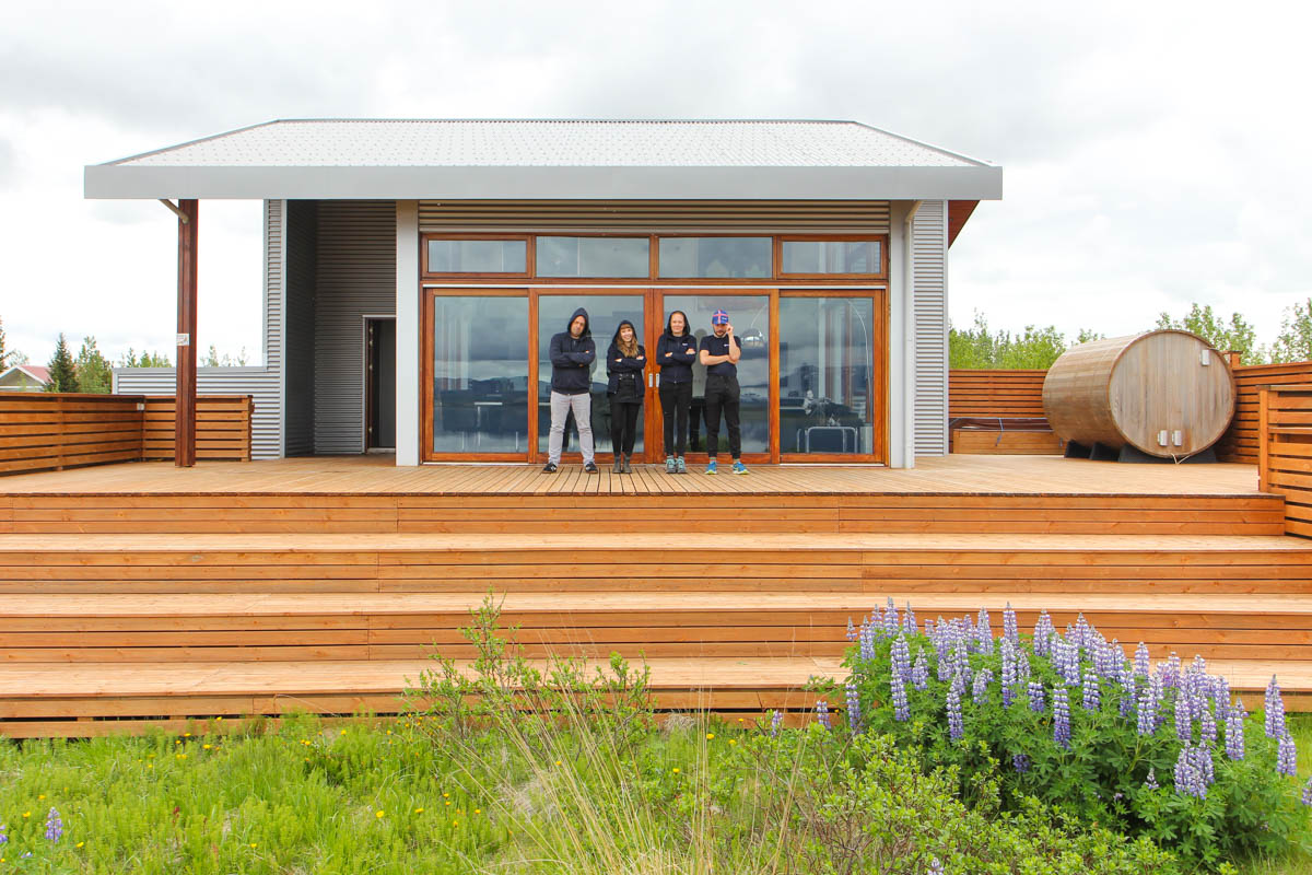 Gruppenfoto vor dem Sommerhaus: Joschi, Nina, Annika und Jeff mit Kapuzen und Caps